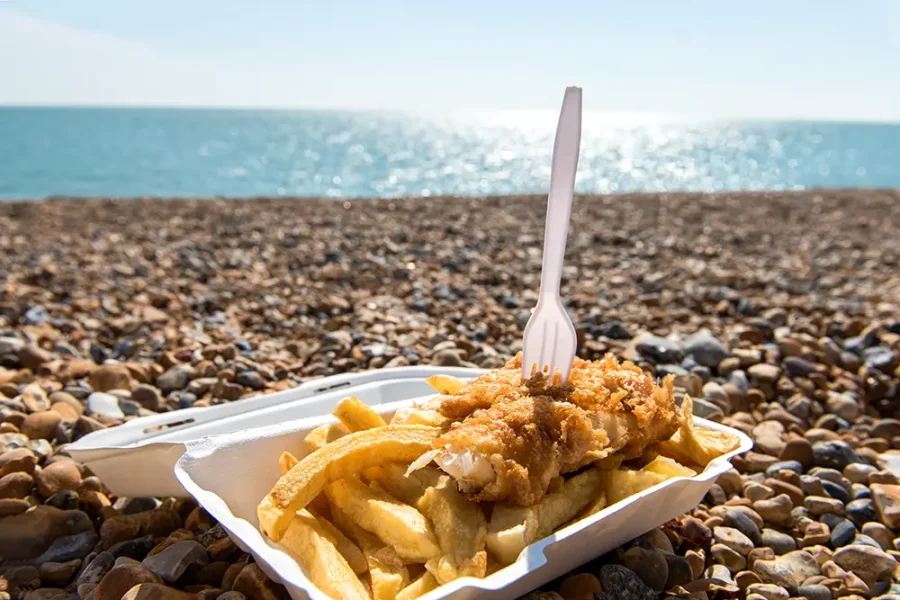 A tray of traditional fish and chips on Brighton beach.