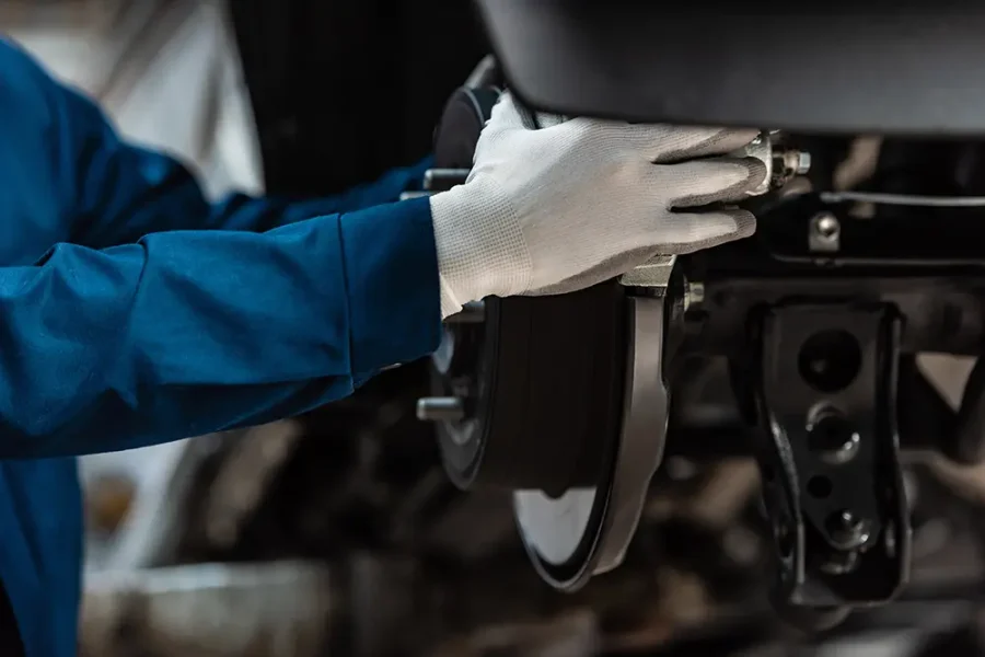 Close up of a car mechanic working on a car's brake disc.